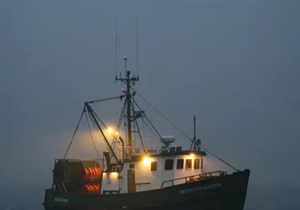 Fishing boat at dusk under full moon