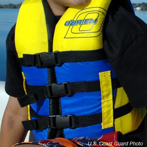 Child wearing yellow and blue life jacket on boat